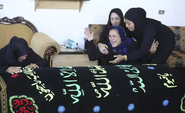 FILE - Relatives of Samira Ayoub, and her three granddaughters, Rimas, 14; Taline, 12, and Liane, 10, weep over their coffins in the town of Ainata, south Lebanon, Tuesday, Nov. 7, 2023, after they were killed in an Israeli drone strike while in a car near the Lebanon-Israel border. (AP Photo/Mohammed Zaatari, File)