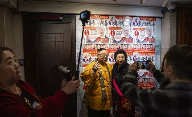 Opera playwright Li Kui-Ming, left, of the Cantonese opera production “Trump on Show,” takes photographs with a member of the audience at the Sunbeam Theatre in Hong Kong, Monday, Feb. 3, 2025. (AP Photo/Chan Long Hei)