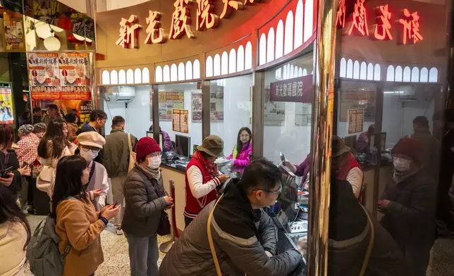 People stand in a queue to purchase tickets outside the box office at the Sunbeam Theatre playing the Cantonese opera production “Trump on Show” in Hong Kong, Monday, Feb. 3, 2025. (AP Photo/Chan Long Hei)