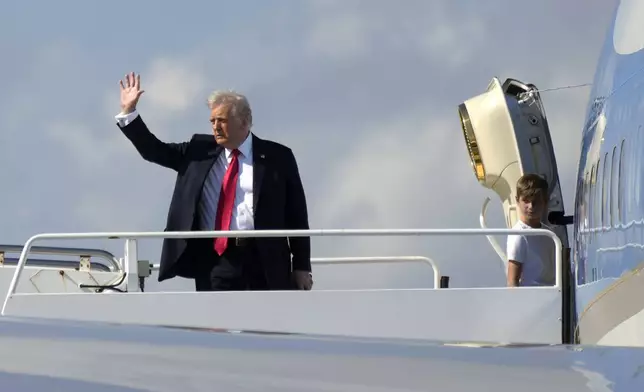 President Donald Trump, left, waves as he boards Air Force One with grandson Theodore, Ivanka Trump's son, at Palm Beach International Airport in West Palm Beach, Fla., Sunday, Feb. 9, 2025. (AP Photo/Ben Curtis)