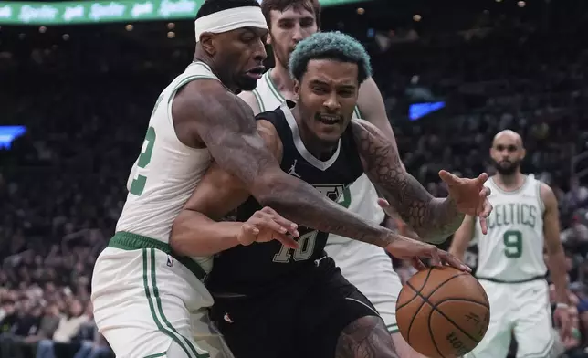 Boston Celtics forward Torrey Craig, left, steals the ball from San Antonio Spurs forward Jeremy Sochan during the first half of an NBA basketball game, Wednesday, Feb. 12, 2025, in Boston. (AP Photo/Charles Krupa)