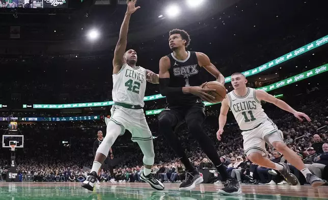 San Antonio Spurs center Victor Wembanyama, center, drives to the basket against Boston Celtics center Al Horford (42) and guard Payton Pritchard (11) during the first half of an NBA basketball game, Wednesday, Feb. 12, 2025, in Boston. (AP Photo/Charles Krupa)