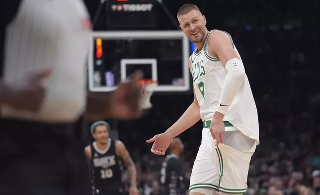 Boston Celtics center Kristaps Porzingis shows his ripped uniform while arguing with officials that he was fouled during the first half of an NBA basketball game against the San Antonio Spurs, Wednesday, Feb. 12, 2025, in Boston. (AP Photo/Charles Krupa)