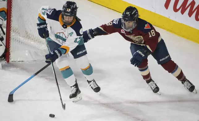 Montreal Victoire's Mikyla Grant-Mentis (18) battles with New York Sirens' Ella Shelton (17) during the second period of a PWHL hockey game in Laval, Quebec, Saturday, Feb. 15, 2025. (Peter McCabe/The Canadian Press via AP)