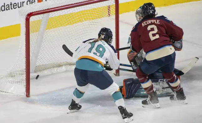 Montreal Victoire Mariah Keopple (2) scores on New York Sirens' Corinne Schroeder (30) during the first period of a PWHL hockey game in Laval, Quebec, Saturday, Feb. 15, 2025. (Peter McCabe/The Canadian Press via AP)