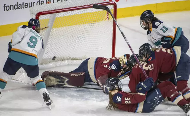 New York Sirens' Jessie Eldridge (9) scores on Montreal Victoire's Ann-Renee Desbiens (35) during the second period of a PWHL hockey game in Laval, Quebec, Saturday, Feb. 15, 2025. (Peter McCabe/The Canadian Press via AP)