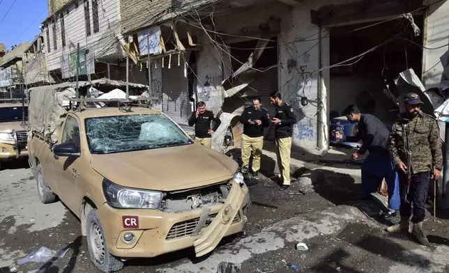 Security officials examine a damaged security forces' vehicle at the site of a bomb blast in Quetta, Pakistan, Friday, Feb. 28, 2025. (AP Photo/Arshad Butt)