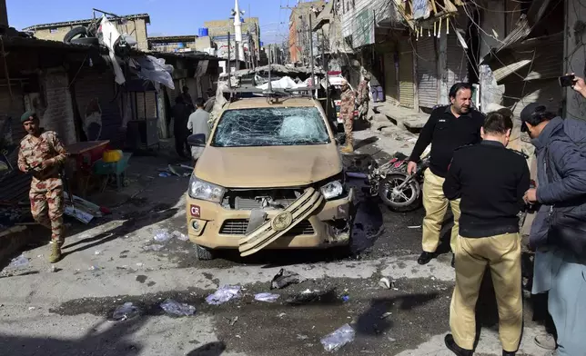 Security officials check a damaged security forces' vehicle at the site of a bomb blast in Quetta, Pakistan, Friday, Feb. 28, 2025. (AP Photo/Arshad Butt)