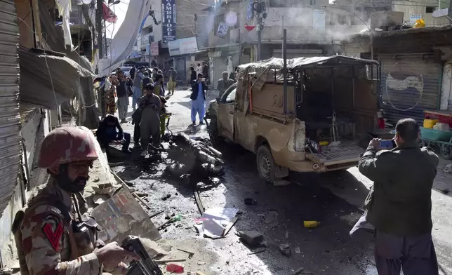 Security officials examine a damaged security forces' vehicle at the site of a bomb blast in Quetta, Pakistan, Friday, Feb. 28, 2025. (AP Photo/Arshad Butt)