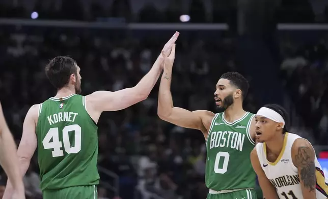 Boston Celtics center Luke Kornet (40) celebrates with forward Jayson Tatum (0) in the second half of an NBA basketball game against the New Orleans Pelicans in New Orleans, Friday, Jan. 31, 2025. (AP Photo/Gerald Herbert)