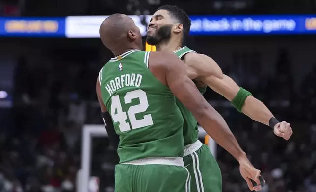 Boston Celtics forward Jayson Tatum celebrates with center Al Horford (42) after his go-ahead, game-winning shot in the final second of the second half of an NBA basketball game in New Orleans, Friday, Jan. 31, 2025. (AP Photo/Gerald Herbert)