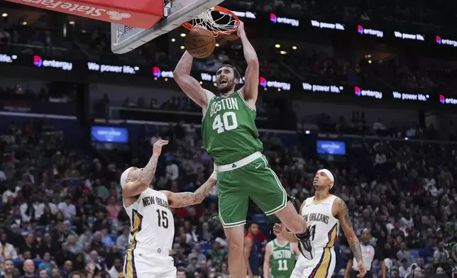 Boston Celtics center Luke Kornet (40) slam dunks over New Orleans Pelicans guard Jose Alvarado (15) and guard Brandon Boston (11) in the second half of an NBA basketball game in New Orleans, Friday, Jan. 31, 2025. (AP Photo/Gerald Herbert)