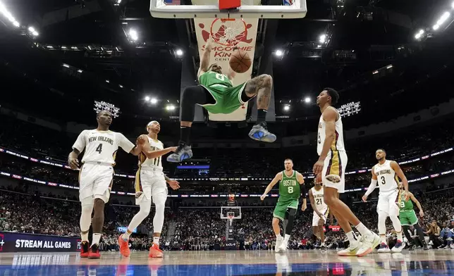 Boston Celtics forward Jayson Tatum (0) slam dunks in the second half of an NBA basketball game against the New Orleans Pelicans in New Orleans, Friday, Jan. 31, 2025. (AP Photo/Gerald Herbert)