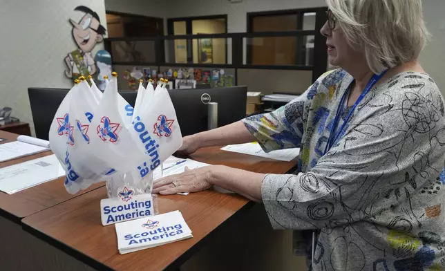Patricia Harrison adjusts items on the counter of Scouting America headquarters in Irving, Texas, Wednesday, Feb. 5, 2025. (AP Photo/LM Otero)