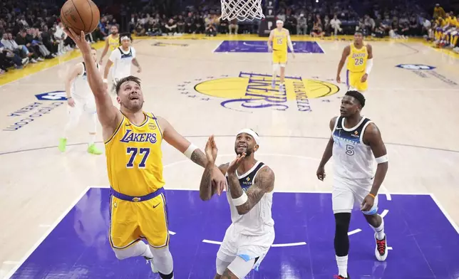 Los Angeles Lakers guard Luka Doncic, left, shoots as Minnesota Timberwolves guard Nickeil Alexander-Walker, center, and guard Anthony Edwards defends during the first half of an NBA basketball game, Thursday, Feb. 27, 2025, in Los Angeles. (AP Photo/Mark J. Terrill)