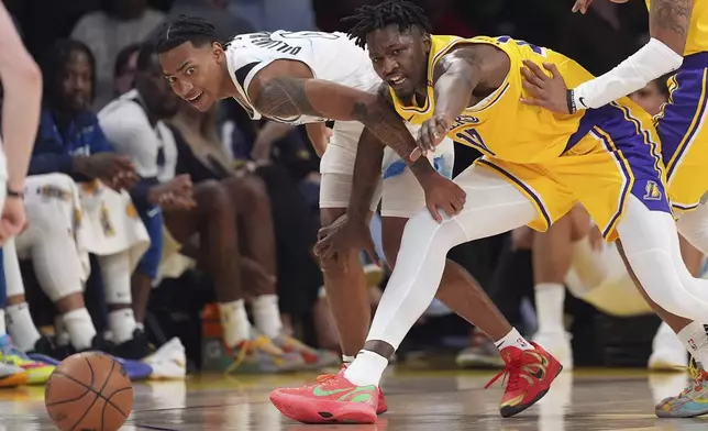 Minnesota Timberwolves guard Rob Dillingham, left, and Los Angeles Lakers forward Dorian Finney-Smith goes after a loose ball during the first half of an NBA basketball game, Thursday, Feb. 27, 2025, in Los Angeles. (AP Photo/Mark J. Terrill)