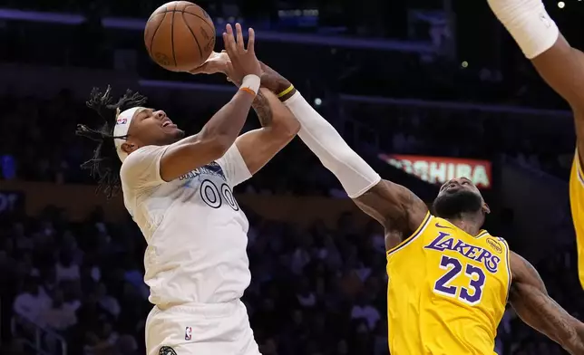 Minnesota Timberwolves guard Terrence Shannon Jr., left, shoots as Los Angeles Lakers forward LeBron James defends during the first half of an NBA basketball game, Thursday, Feb. 27, 2025, in Los Angeles. (AP Photo/Mark J. Terrill)