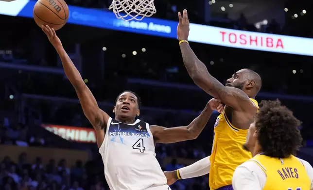 Minnesota Timberwolves guard Rob Dillingham, left, shoots as Los Angeles Lakers forward LeBron James, center, defends along with center Jaxson Hayes during the first half of an NBA basketball game, Thursday, Feb. 27, 2025, in Los Angeles. (AP Photo/Mark J. Terrill)