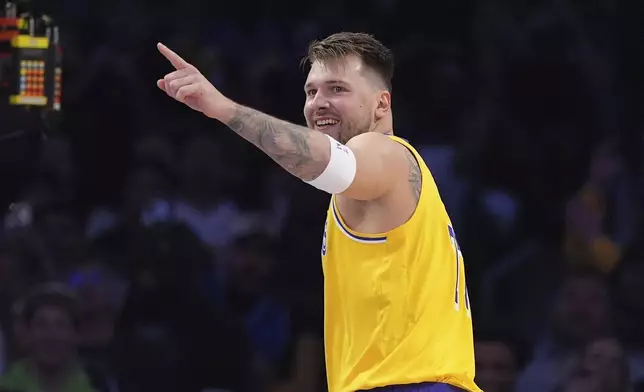Los Angeles Lakers guard Luka Doncic gestures toward forward LeBron James after he scored with an assist by James during the first half of an NBA basketball game against the Minnesota Timberwolves, Thursday, Feb. 27, 2025, in Los Angeles. (AP Photo/Mark J. Terrill)