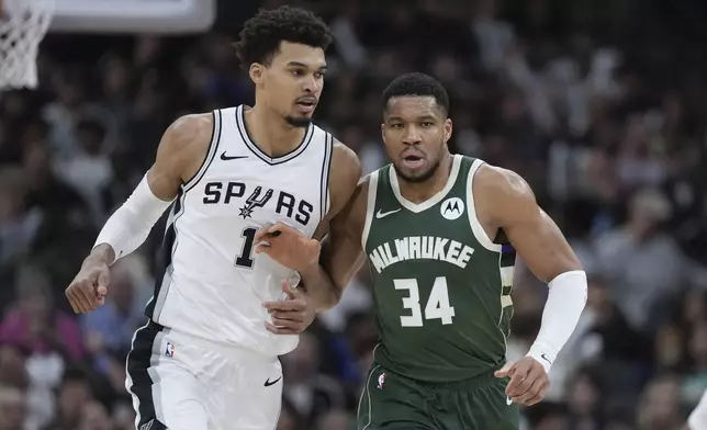 San Antonio Spurs center Victor Wembanyama (1) and Milwaukee Bucks forward Giannis Antetokounmpo (34) jockey for position during the second half of an NBA basketball game in San Antonio, Friday, Jan. 31, 2025. (AP Photo/Eric Gay)