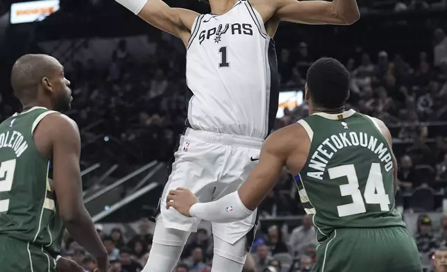 San Antonio Spurs center Victor Wembanyama (1) drives to the basket over Milwaukee Bucks forward Giannis Antetokounmpo (34) during the second half of an NBA basketball game in San Antonio, Friday, Jan. 31, 2025. (AP Photo/Eric Gay)