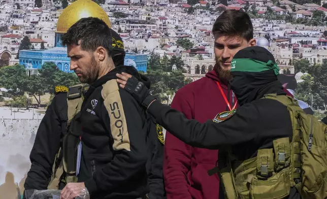 Israeli-American hostage Sagui Dekel Chen, 36, left, and Israeli-Russian Alexander Troufanov, 29, are escorted by Hamas and Islamic Jihad fighters before being handed over to the Red Cross in Khan Younis, Gaza Strip, Saturday, Feb. 15, 2025. (AP Photo/Abdel Kareem Hana)
