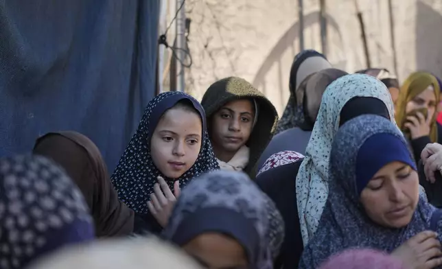 Palestinians queue for food distribution in Deir al-Balah, Gaza Strip, Friday, Feb. 14, 2025. (AP Photo/Abdel Kareem Hana)