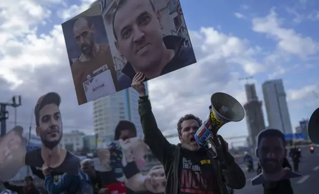 A demonstrator holding photos of freed Israeli hostage Eli Sharabi before and after his captivity blocks a highway during a protest demanding all hostages release from Hamas captivity, in Tel Aviv, Israel, Thursday, Feb. 13, 2025. (AP Photo/Oded Balilty)