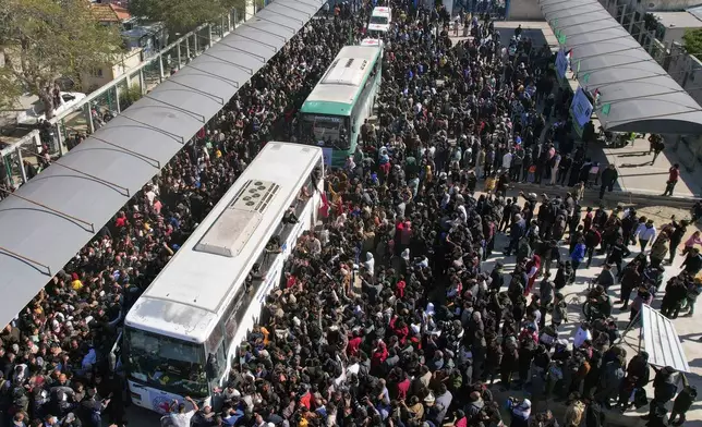 A crowd surrounds the buses carrying freed Palestinian prisoners as they a arrive in Khan Younis, Gaza Strip, Saturday, Feb. 15, 2025. (AP Photo/Mohammad Abu Samra)