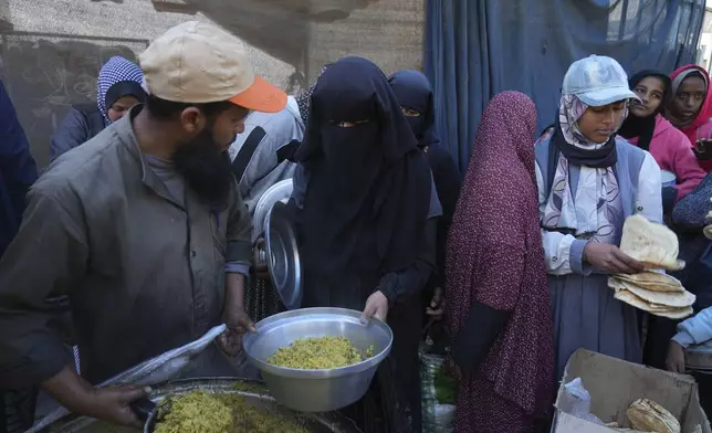 Palestinians queue for food distribution in Deir al-Balah, Gaza Strip, Friday, Feb. 14, 2025. (AP Photo/Abdel Kareem Hana)