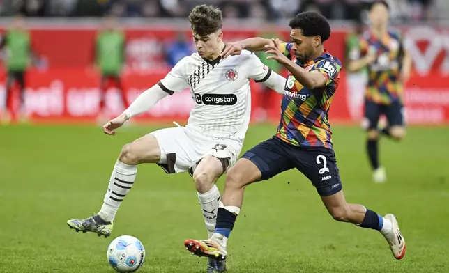 St. Pauli's Noah Weißhaupt, left and Mainz's Phillipp Mwene challenge for the ball during the German Bundesliga soccer match between 1. FSV Mainz 05 and FC St. Pauli in Mainz, Germany, Saturday, Feb. 22, 2025. (Uwe Anspach/dpa via AP)