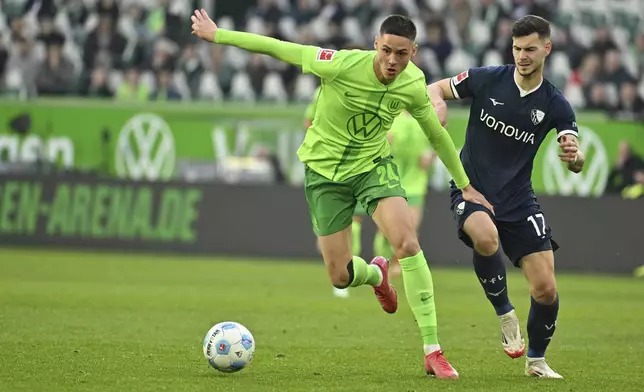 Wolfsburg's Bence Dardai, left, and Bochum's Tom Krauss in action during the Bundesliga soccer match between VfL Wolfsburg and VfL Bochum at Volkswagen Arena, Wolfsburg, Germany, Saturday Feb. 22, 2025. (Swen Pförtner/dpa via AP)
