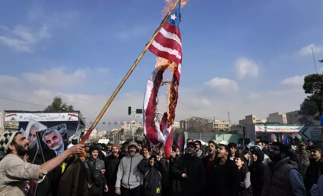 Iranian demonstrators burn a representation of the U.S. flag during a rally commemorating anniversary of 1979 Islamic Revolution that toppled the late pro-U.S. Shah Mohammad Reza Pahlavi and brought Islamic clerics to power, in Tehran, Iran, Monday, Feb. 10, 2025. (AP Photo/Vahid Salemi)
