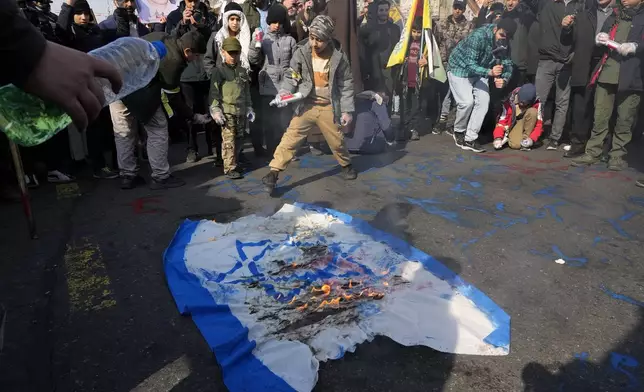 Iranian demonstrators burn a representation of the Israeli flag during a rally commemorating anniversary of Iran's 1979 Islamic Revolution that toppled the late pro-U.S. Shah Mohammad Reza Pahlavi and brought Islamic clerics to power, in Tehran, Iran, Monday, Feb. 10, 2025. (AP Photo/Vahid Salemi)