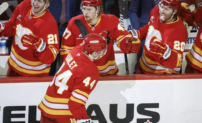 Calgary Flames' Joel Hanley (44) celebrates his goal with teammates during the third period of an NHL hockey game in Calgary, Alberta, Sunday, Feb. 23, 2025. (Jeff McIntosh/The Canadian Press via AP)