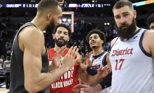 Washington Wizards guard Jordan Poole, second from right, and Minnesota Timberwolves center Rudy Gobert, left, exchange words after an NBA basketball game Saturday, Feb. 1, 2025, in Minneapolis. (AP Photo/Matt Krohn)