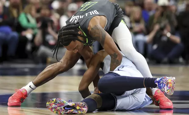 Minnesota Timberwolves guard Rob Dillingham, top, and Washington Wizards guard Jordan Poole compete for the ball during the second half of an NBA basketball game Saturday, Feb. 1, 2025, in Minneapolis. (AP Photo/Matt Krohn)