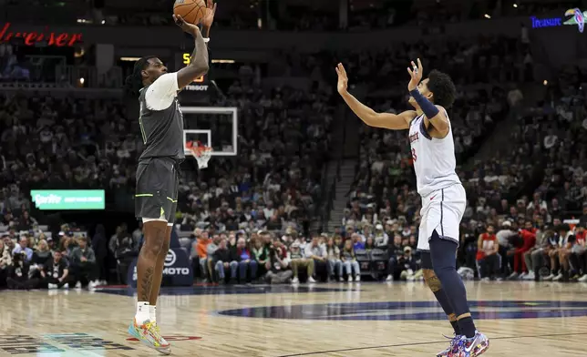 Minnesota Timberwolves center Naz Reid, left, shoots as Washington Wizards guard Jordan Poole, right, defends during the first half of an NBA basketball game Saturday, Feb. 1, 2025, in Minneapolis. (AP Photo/Matt Krohn)