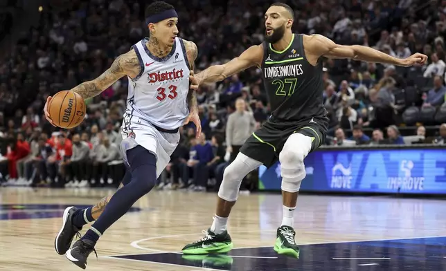 Washington Wizards forward Kyle Kuzma, left, works around Minnesota Timberwolves center Rudy Gobert during the second half of an NBA basketball game Saturday, Feb. 1, 2025, in Minneapolis. (AP Photo/Matt Krohn)