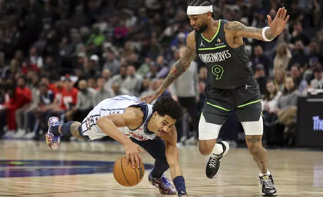 Washington Wizards guard Jordan Poole, left, controls the ball as Minnesota Timberwolves guard Nickeil Alexander-Walker defends during the second half of an NBA basketball game Saturday, Feb. 1, 2025, in Minneapolis. (AP Photo/Matt Krohn)