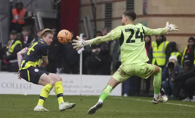 Manchester City's Kevin De Bruyne, left, scores his side's second goal during the English FA Cup fourth round soccer match between Leyton Orient and Manchester City at the Gaughan Group Stadium in London, England, Saturday, Feb. 8, 2025. (AP Photo/Kin Cheung)