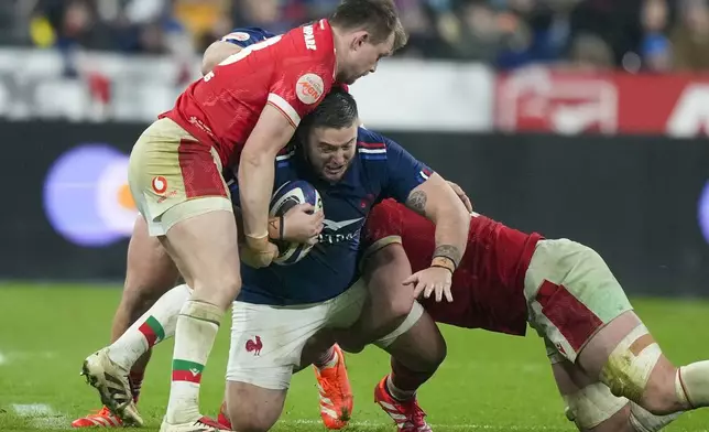 France's Cyril Baille, center, is tackled during the Six Nations rugby union match between France and Wales at the Stade de France in Saint-Denis, outside Paris, Friday, Jan. 31, 2025. (AP Photo/Michel Euler)
