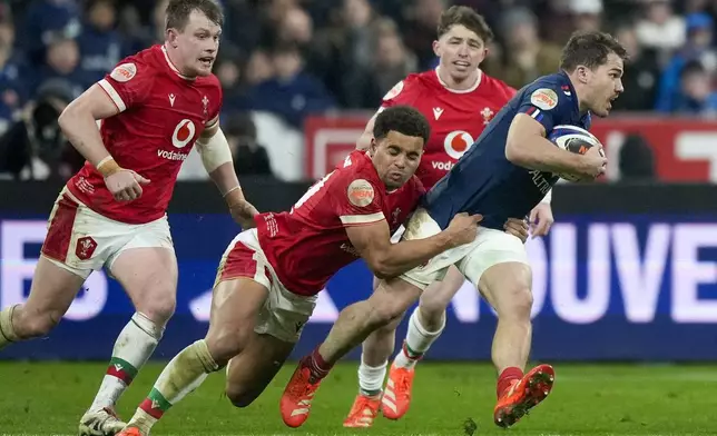 France's Antoine Dupont is tackled by Wales' Ben Thomas during the Six Nations rugby union match between France and Wales at the Stade de France in Saint-Denis, outside Paris, Friday, Jan. 31, 2025. (AP Photo/Michel Euler)