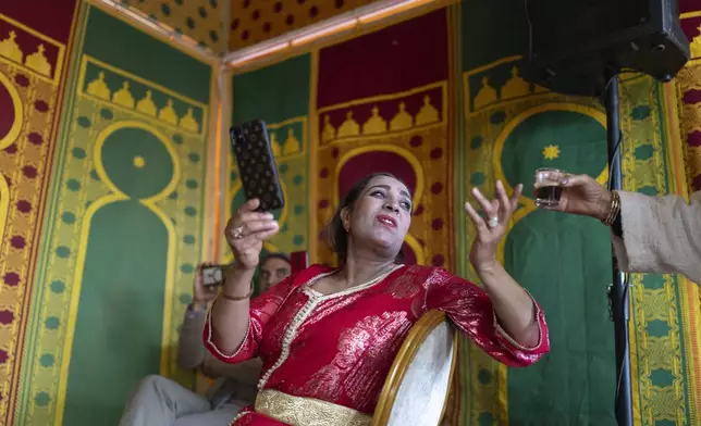 Cheikha folk singer Mbarka "Thouria" Moullablad drinks a coffee during a traditional performance known as Aita, in Sidi Yahya Zaer, south of the capital Rabat, Morocco, Monday, Jan. 27, 2025. (AP Photo/Mosa'ab Elshamy)