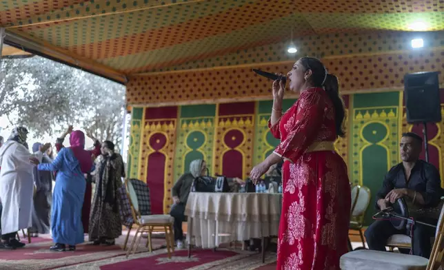 Women dance as Cheikha folk singer Mbarka ''Thouria'' Moullablad gives a traditional performance known as Aita, in Sidi Yahya Zaer, south of the capital Rabat, Morocco, Monday, Jan. 27, 2025. (AP Photo/Mosa'ab Elshamy)