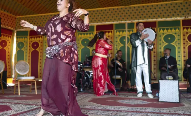 A woman dances during a traditional performance known as Aita, in Sidi Yahya Zaer, south of the capital Rabat, Morocco, Monday, Jan. 27, 2025. (AP Photo/Mosa'ab Elshamy)