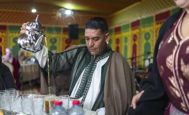 Moroccan tea is distributed during a traditional performance known as Aita, in Sidi Yahya Zaer, south of the capital Rabat, Morocco, Monday, Jan. 27, 2025. (AP Photo/Mosa'ab Elshamy)