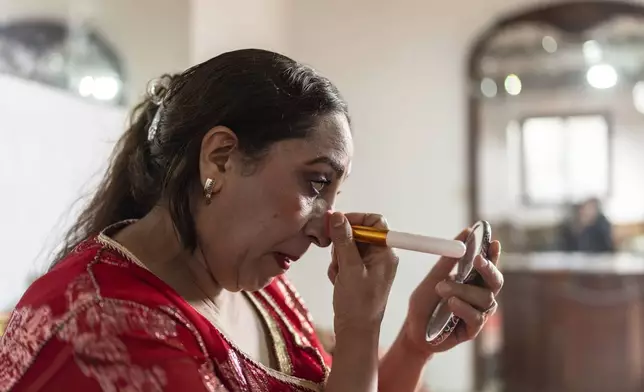 Cheikha folk singer Mbarka "Thouria" Moullablad applies makeup as she prepares for a traditional performance known as Aita, in Sidi Yahya Zaer, south of the capital Rabat, Morocco, Monday, Jan. 27, 2025. (AP Photo/Mosa'ab Elshamy)