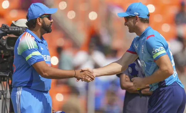 India's captain Rohit Sharma, left, shakes hand with his England counterpart Jos Buttler after the coin toss for the third one day international cricket match between India and England in Ahmedabad , India, Wednesday, Feb. 12, 2025. (AP Photo/ Ajit Solanki )