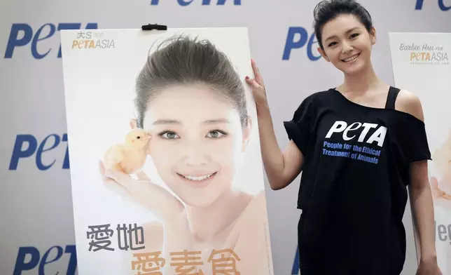 FILE - Taiwanese actress Barbie Hsu, better known as "Da S" which means "Big S," unveils her new poster for People for the Ethical Treatment of Animals (PETA) Asia in Beijing on Nov. 26, 2009. The Chinese characters on the poster reads "Vegetarians Make Chicks Happy!" (AP Photo/Andy Wong, File)
